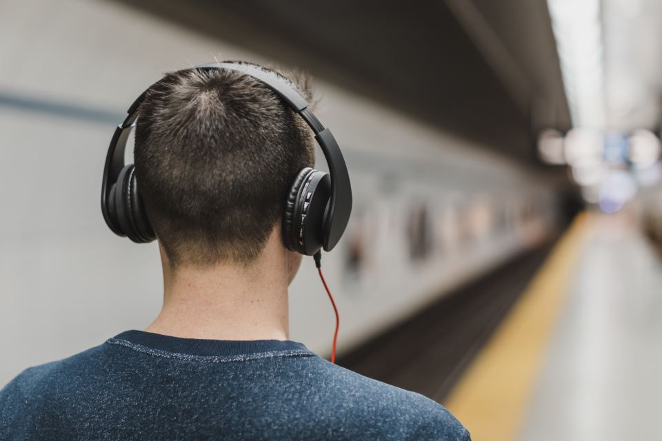 Man with headphones waiting on a metro platform