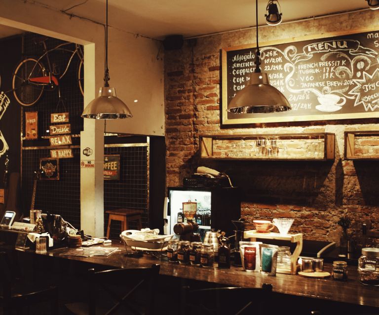 Warm, dimly lit café interior with brick walls and a coffee bar