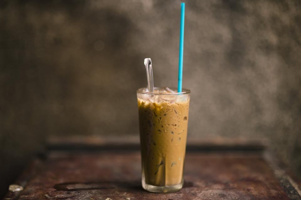 A tall blended iced coffee with a straw