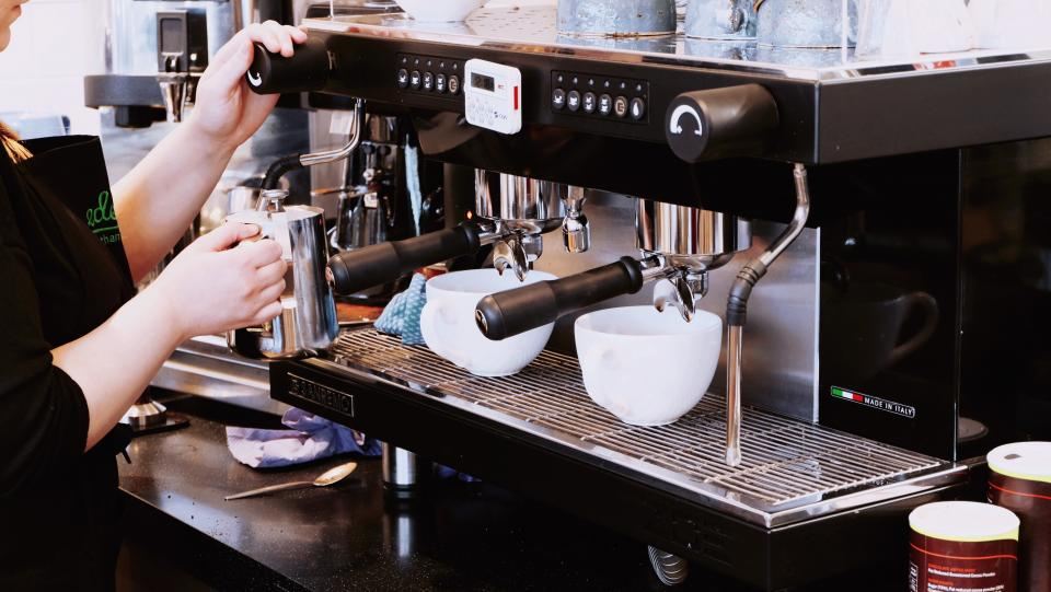 Barista steaming milk at an espresso machine