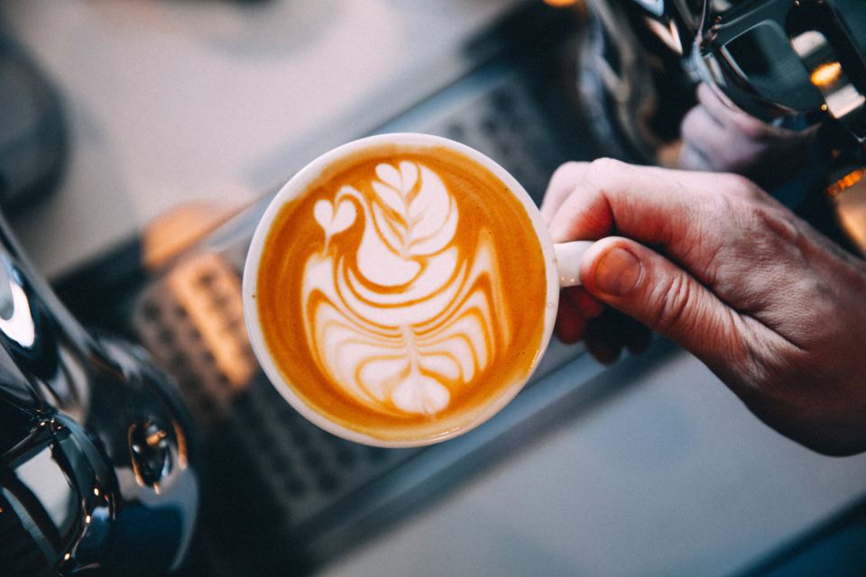 Barista holding a cappuccino with rosetta latte art