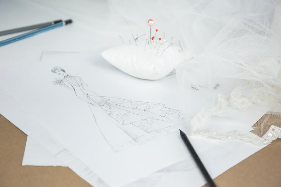 A pencil sketch of a dress design on paper