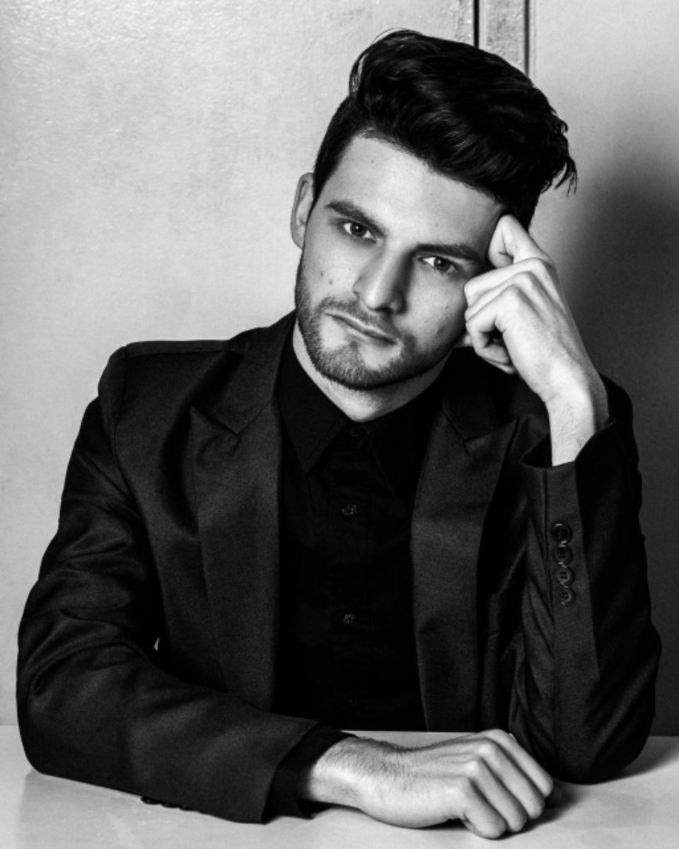 Black and white portrait of a man in a black wool blazer