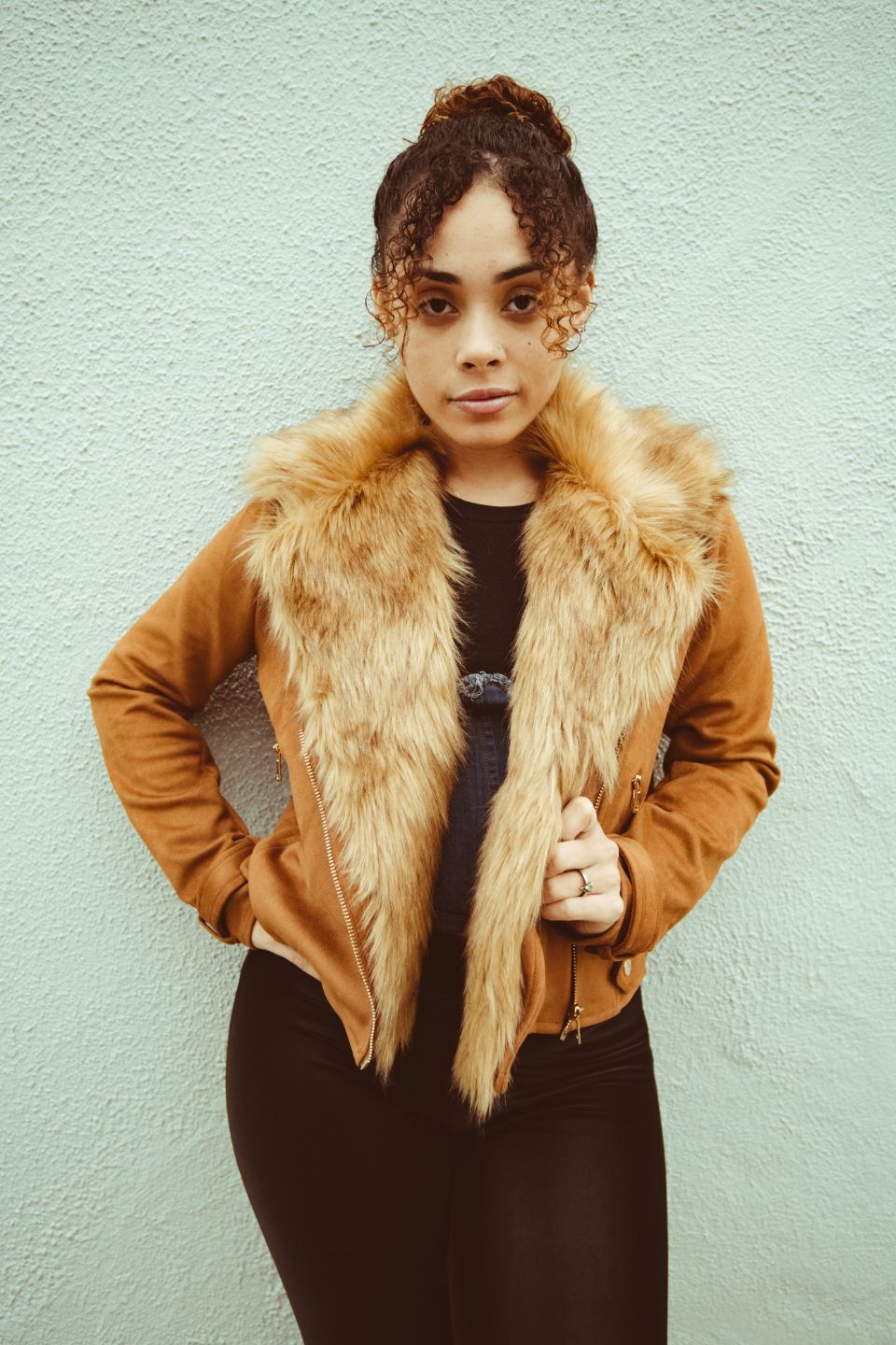 Woman in a tan jacket with a faux-fur collar