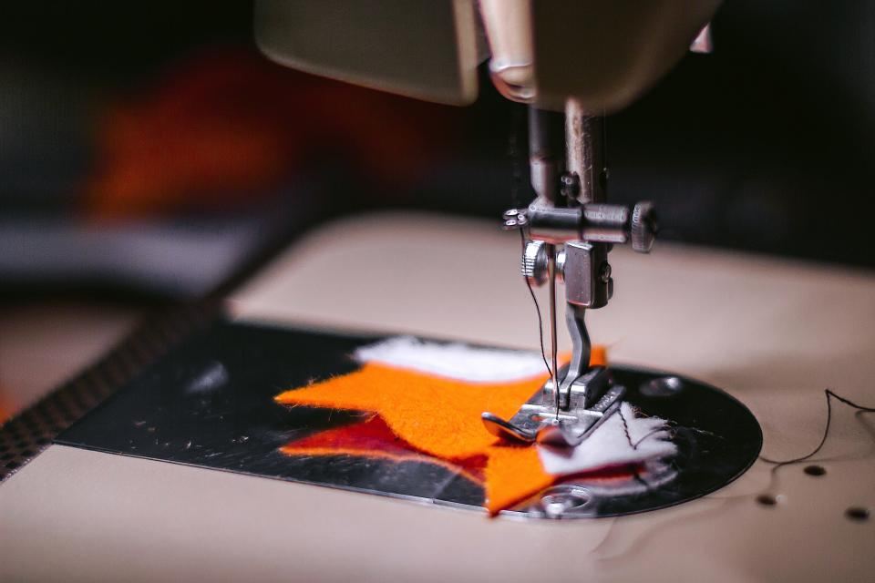 A sewing machine needle stitching fabric