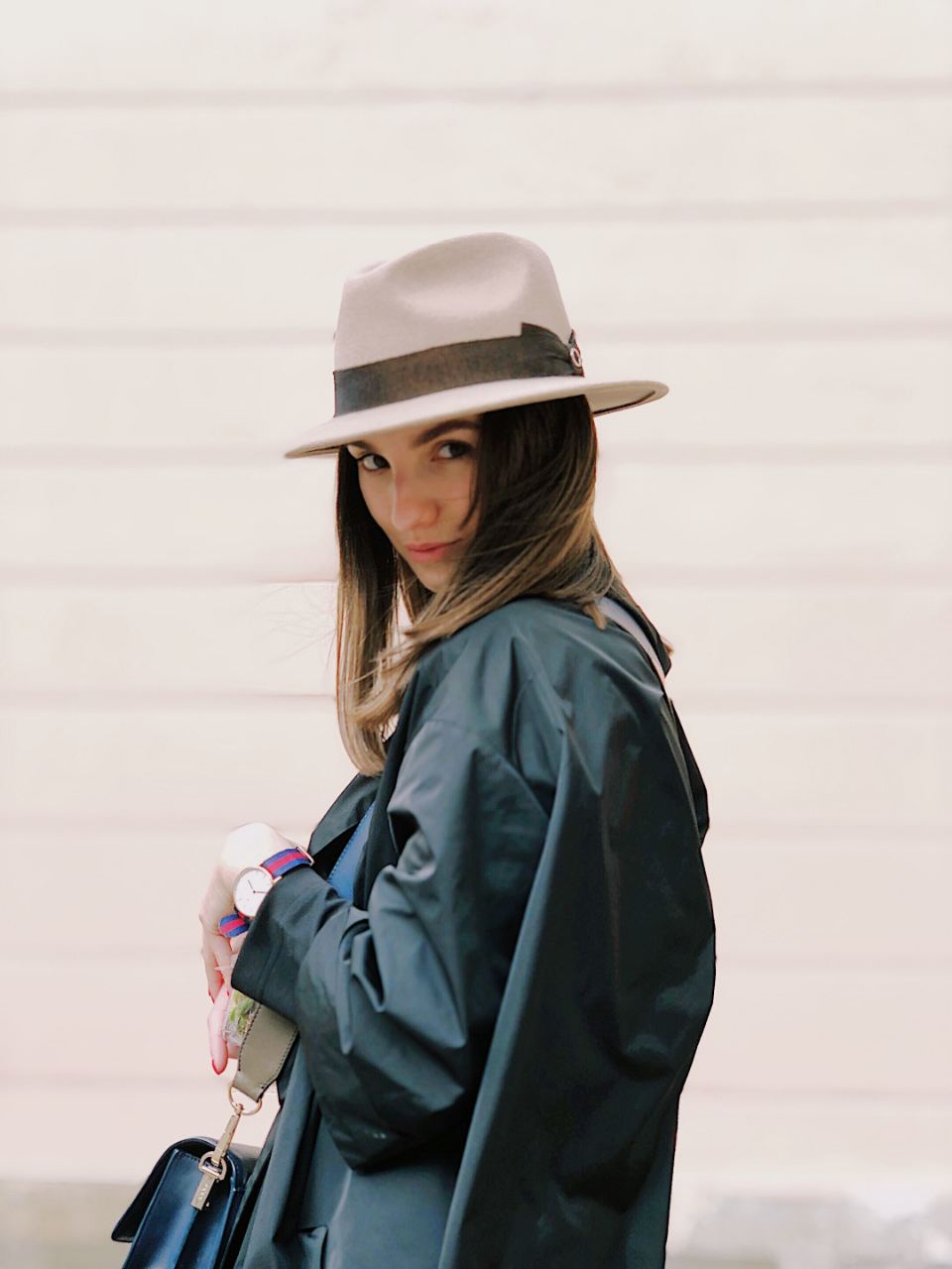 Woman in a taupe felt fedora and a dark teal coat