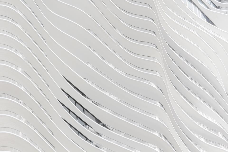 Curved white balconies of a residential tower, close up