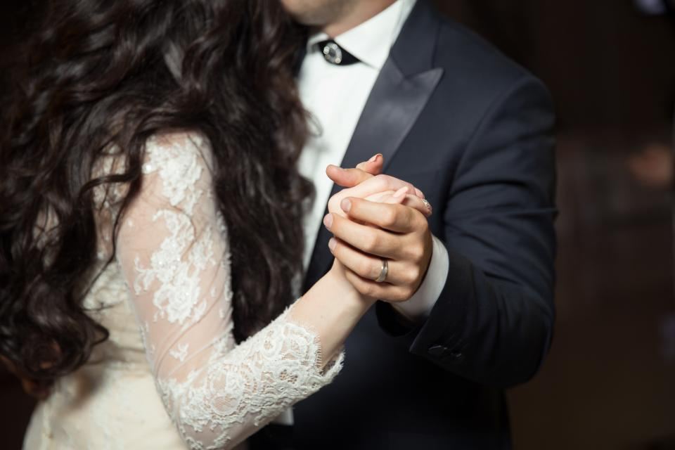 Bride and groom dancing close, holding hands