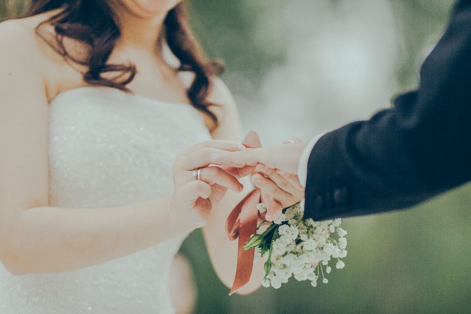 Bride holding the groom's hand, a small bouquet at her wrist