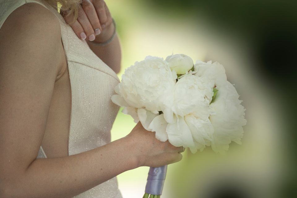 Bride holding a white peony bouquet