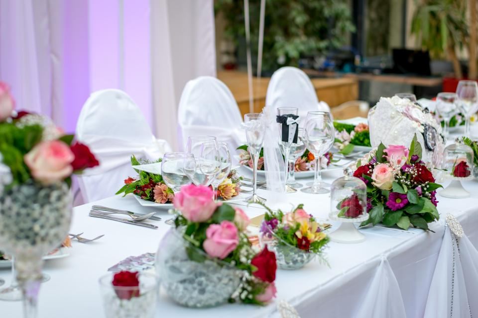Reception table set with roses, white chairs and glassware