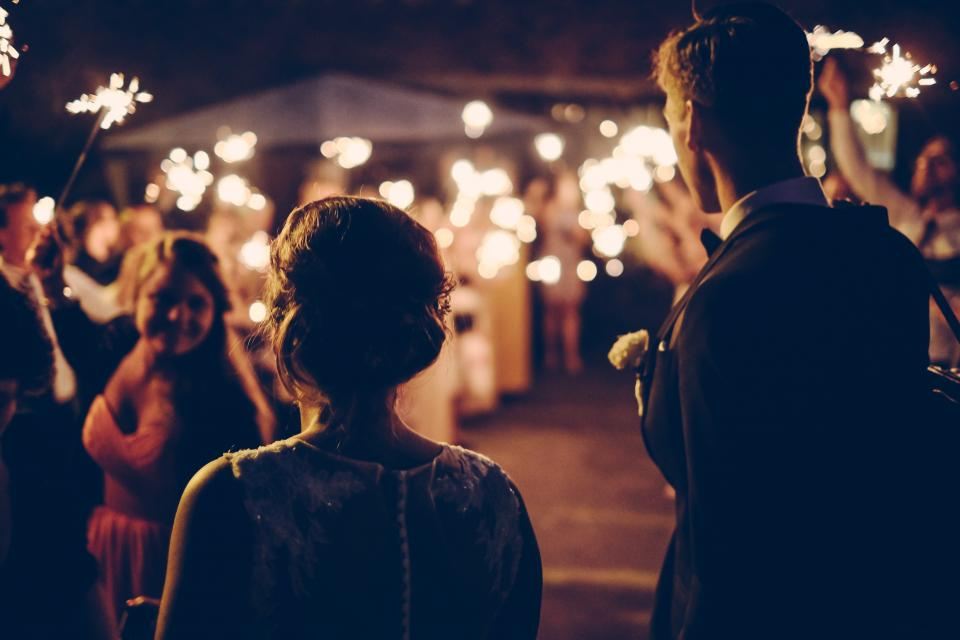Guests holding sparklers at an evening celebration